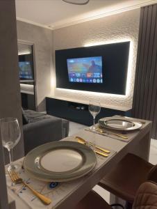 a dining room with a table with plates and wine glasses at GRU Airport 4km, 2 Dorms, Bosque Maia in Guarulhos +11 photos
