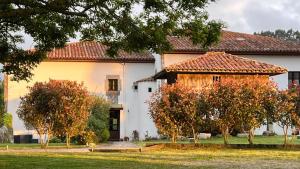a white house with trees in front of it at La Ribera de Pría in Villanueva de Pría