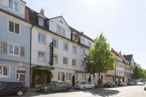 a hotel with cars parked in front of it on a street at Hotel JÄGERHAUS in Singen am Hohentwiel in Singen