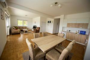 a kitchen and living room with a wooden table and chairs at Villa Sarajevo 3 in Sarajevo