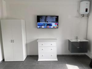 a bathroom with a sink and a tv on the wall at Pension Mühlental Hüllhorst in Hüllhorst