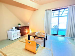 a living room with a table and a chair at プログレスヒルズ in Tokyo