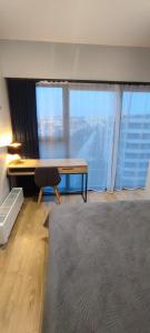 een slaapkamer met een bed, een bureau en ramen bij GOLD APARTMENTS Capital Towers in Rzeszów