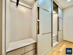 Kampong BaharuPine Tree Suites by RR JBcity的步入式衣柜,配有白色橱柜和玻璃门