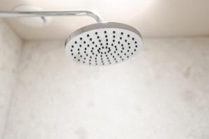 a shower with a metal shower head on a wall at Grove House Hotel in Edinburgh