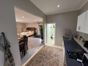 a kitchen with a sink and a bedroom with a bed at B&B At 66 Henderson in Claredon