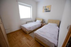 two beds in a small room with a window at Villa Sarajevo 5 in Sarajevo