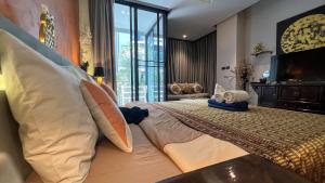a bedroom with a large bed with pillows on it at Relife Windy by Nataly in Phuket Town +39 photos