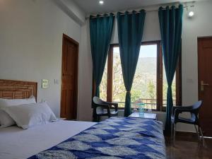 a bedroom with a bed and a large window at Kabila King Resort in Chakrāta