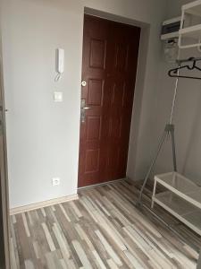 pokój z brązowymi drzwiami i statywem w obiekcie Apartament Morski w mieście Puck