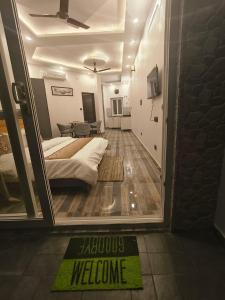 a bedroom with a bed and a welcome sign on the floor at Nature Oaks Luxury stayz Nainital in Bhīm Tāl