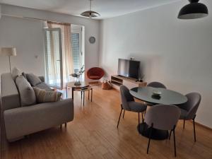 a living room with a couch and a table and chairs at Apartments 402 in Bar