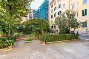 un patio con plantas, árboles y edificios en Vatican Essence, en Roma