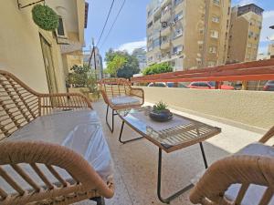 a patio with chairs and a table with a plant on it at Albert's Apartment Mackenzie 001 in Larnaka