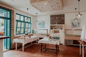 a room with two tables and a kitchen at Fészek -Étel és Hotel-Zánka in Zánka
