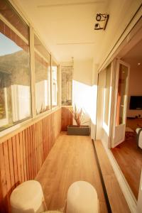 a room with wooden floors and white chairs and windows at L'Edelweiss - Au pied des montagnes in La Lechere