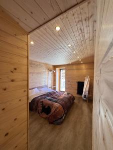 a bedroom in a log cabin with a bed in it at Etna Chalet Nicolosi in Nicolosi