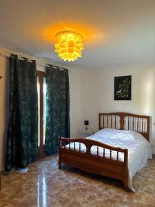 une chambre avec un lit et un lustre dans l'établissement Villa familiale piscine privée 6 personnes Proche plage 6PC7, à Saint-Laurent-de-la-Salanque