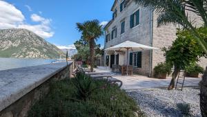 a building with an umbrella next to the water at Villa Toma in Donji Morinj