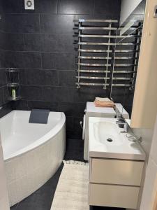 a bathroom with a white tub and a sink at Avangard in Chernivtsi
