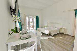 a white room with a bed and a table at VILLA IRMA in Varigotti
