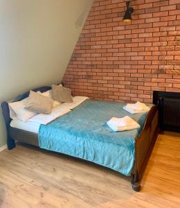 a bed in a room with a brick wall at Apartamenty w centrum Wawel & Smok AC Progres in Toruń