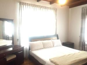 a bedroom with a bed and a large window at The Hikers Home in Nuwara Eliya