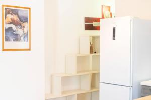 cocina con nevera blanca y estanterías en Girasole, en Posada