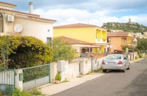 un coche aparcado en una calle al lado de las casas en Girasole, en Posada
