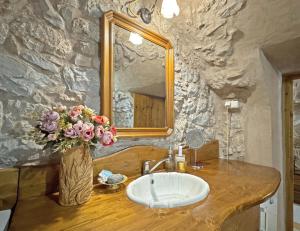 a bathroom with a sink and a mirror and flowers at Lina's Art and Stone Studio in Verga Kalamata +46 photos