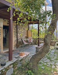 a patio with a table and a tree at Lina's Art and Stone Studio in Verga Kalamata