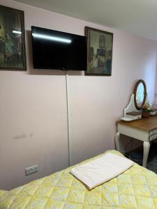 Bishops CleeveにあるEdgecoteのベッドルーム1室(ベッド1台、壁掛けテレビ付)