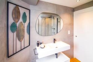 ein Badezimmer mit Waschbecken und Spiegel in der Unterkunft Balea in Hondarribia