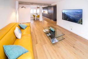 ein Wohnzimmer mit einem gelben Sofa und einem Glastisch in der Unterkunft Balea in Hondarribia