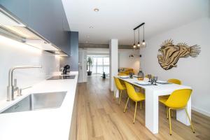 eine Küche und ein Esszimmer mit einem weißen Tisch und gelben Stühlen in der Unterkunft Balea in Hondarribia
