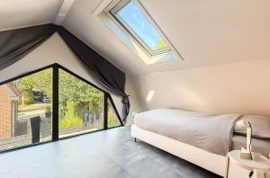 a bedroom with a bed and a large window at 't Boschhuys by Droomvilla in Bergen