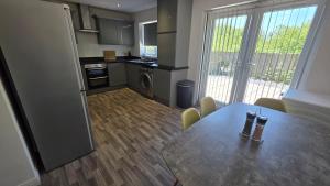 cocina con mesa de madera y cocina con comedor en 4 Bedroom Home Tameside Greater Manchester Sleeps 8, en Mánchester 20 fotos más