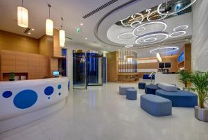 a hospital lobby with a waiting area and blue chairs at Al Khoory Inn Bur Dubai in Dubai
