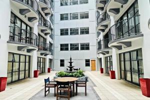 a courtyard with a table and chairs in a building at Quest Atrium Apartment Hotel in Wellington