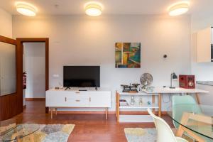 a living room with a tv and a white cabinet at Fabuloso apartamento con piscina in Vargas