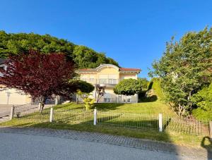 a large house with a fence in front of it at Bergperle am Lindberg in Perlesreut +5 photos