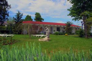 a house with a yard with a bench in front of it at Boemul Neptun in Neptun