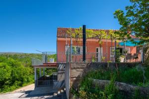 a house with a balcony and a building at House MM in Čavoglave