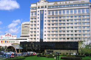 a large white building with people in front of it at Kunming Hotel in Kunming