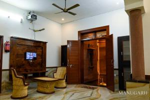 a living room with chairs and a table and a ceiling at MANUGARH The heritage Palace in Jodhpur