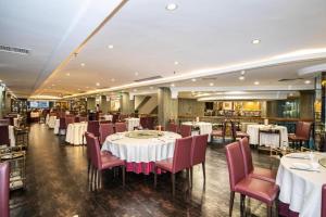 a dining room with white tables and red chairs at Shunde Emperor Hotel in Shunde