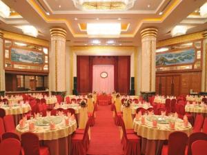 a banquet hall with tables and chairs and a clock at Haikou Conifer Garden Hotel in Haikou
