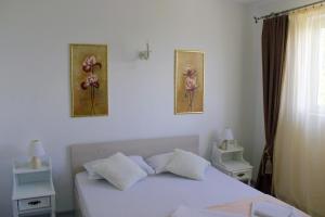 a bedroom with a white bed with two pictures on the wall at Boemul Neptun in Neptun +98 photos