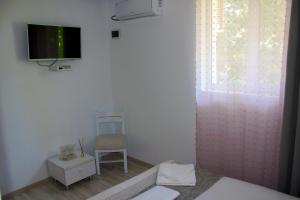 a bedroom with a chair and a tv on the wall at Boemul Neptun in Neptun