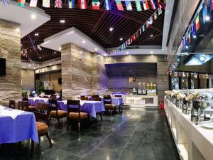a restaurant with purple tables and chairs and flags at Royal Duke Cherrabah Hotel Zhongshan in Yagang